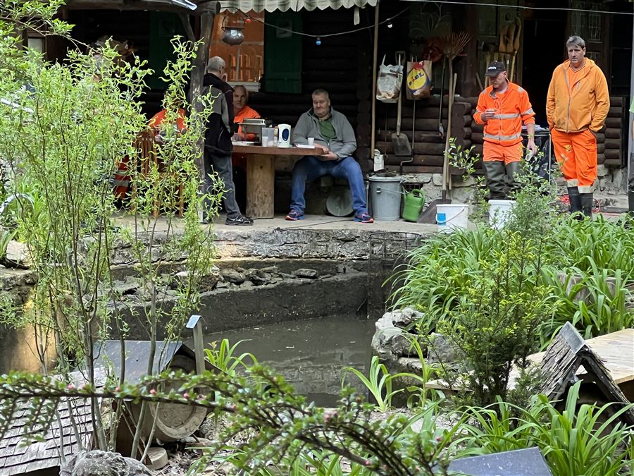 Helfer machen Pause beim Clubhaus am Weiher